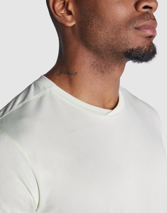 Close-up van de nek en schouder van een lichtgroen Roly sportshirt met korte mouwen.