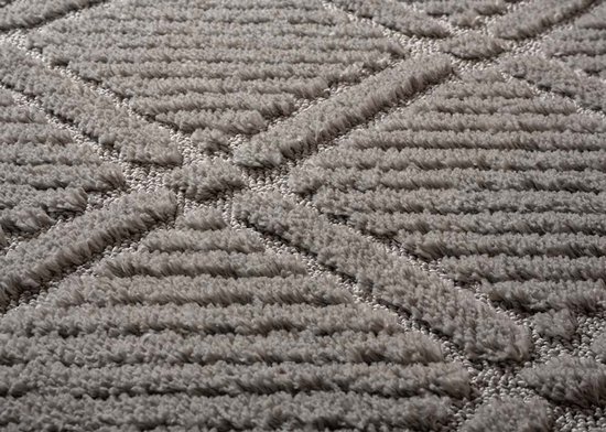 Gros plan du relief et de la texture du tapis gris clair à motif losange.