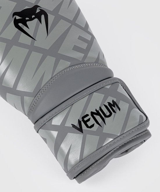 Close-up van grijze bokshandschoen met Venum-logo en patroon.