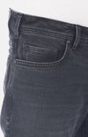 Detail van de zak van een donkergrijze jeans. De zak heeft een metalen knoopje.