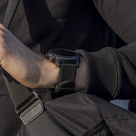 Persoon met een zwarte smartwatch met rubberen band om de pols.