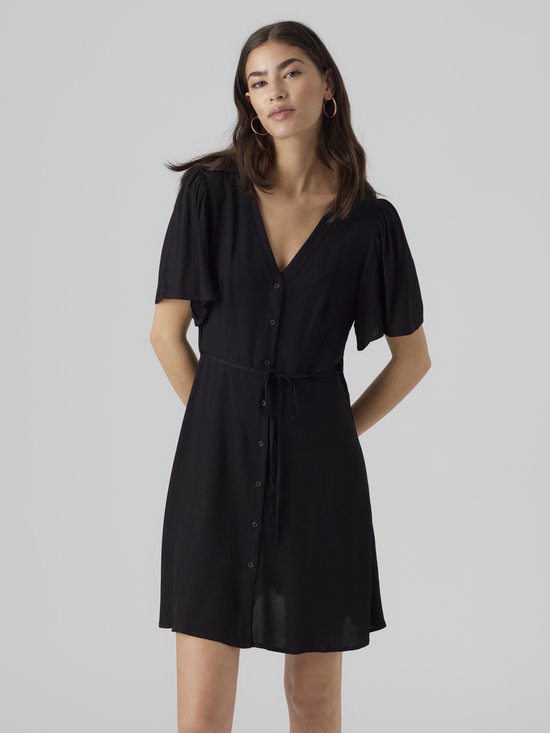 Mannequin portant une robe noire col en V, boutonnée, avec ceinture à nouer. Manches courtes bouffantes.