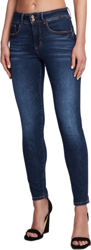 Jeans skinny bleu foncé avec un léger délavage sur les cuisses et une double fermeture à boutons.