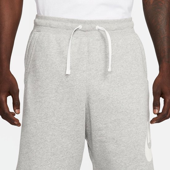 Lichtgrijze joggingbroek met een trekkoord en steekzakken. De tailleband is zichtbaar.