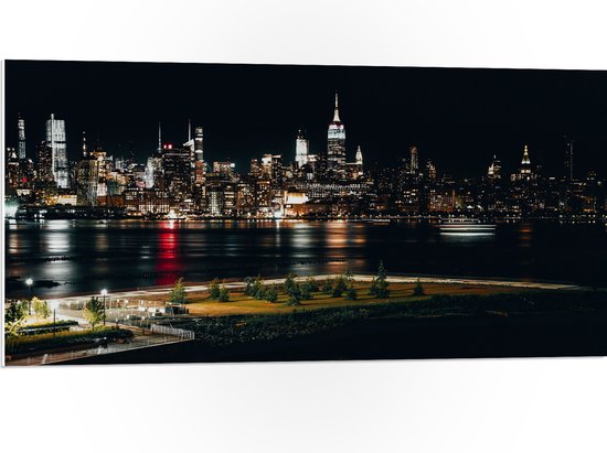 PVC Schuimplaat - Skyline in New York in de Nacht - 100x50 cm Foto op PVC Schuimplaat (Met Ophangsysteem)