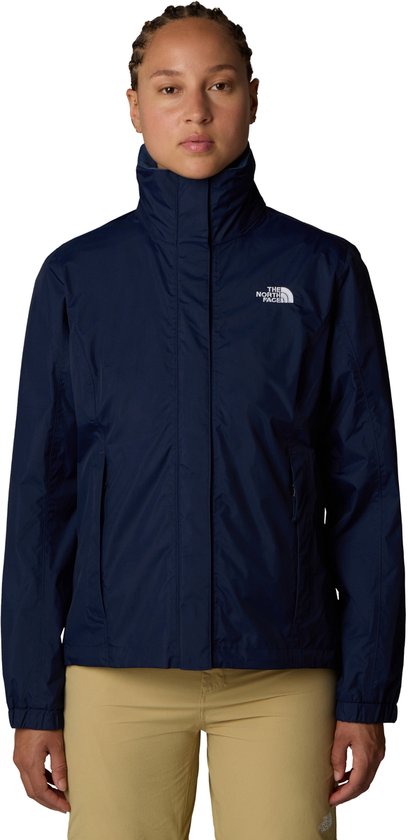 Dames in donkerblauwe The North Face jas met capuchon en beige broek.