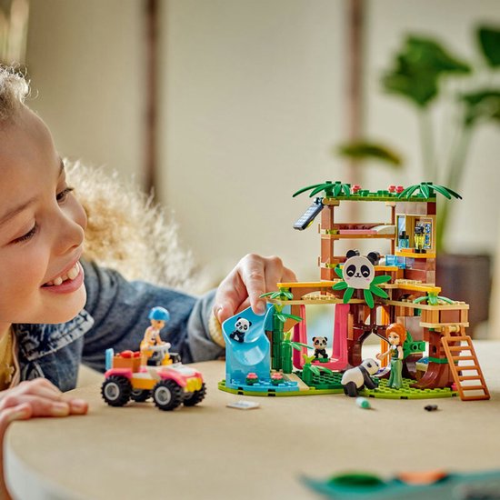 Kind met LEGO Friends De Pandaopvang speelset. Met boomhut, glijbaan, quad, minipoppen en pandabeertjes.