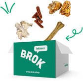 Verzenddoos van BROK met diverse hondensnacks die eruit springen: buffelhuidbeen, runderneuzen, snackworstjes en runderknieschijf.