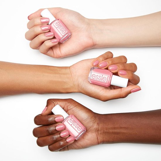 Drie handen met verschillende huidskleuren, elk met een flesje Essie nagellak en gelakte nagels in roze tinten.