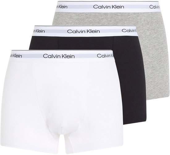Drie Calvin Klein trunks, wit, zwart en grijs, elk met logo-band.