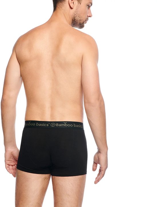 Man, gezien vanaf de achterkant, draagt een zwarte bamboe boxershort met 'Bamboo Basics' logo op de band.