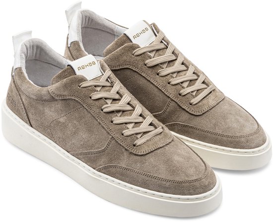Twee taupe suède sneakers met veters, witte zolen en witte details op de hiel.