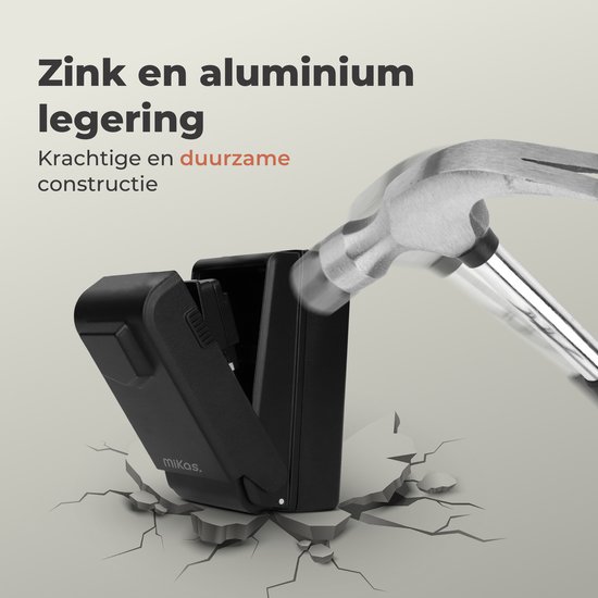 Zwarte sleutelkluis wordt geraakt door een hamer en breekt door de ondergrond.