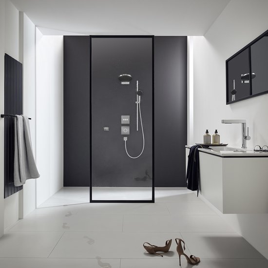 Strakke badkamer met zwarte douchewand, chromen douche en zwevend wastafelmeubel.