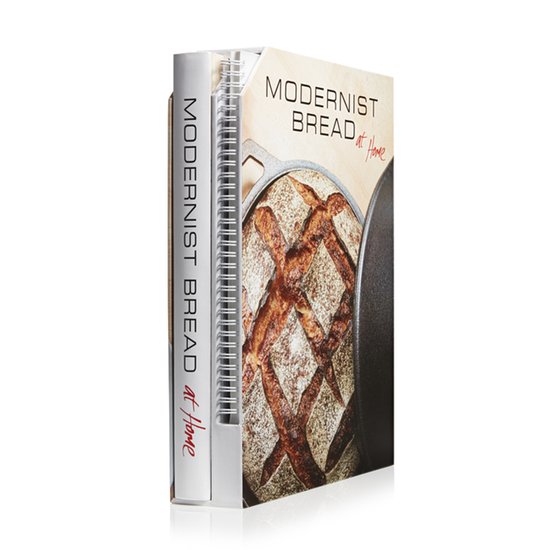 Boek "MODERNIST BREAD at Home" met op de kaft een versgebakken brood in een gietijzeren pan.