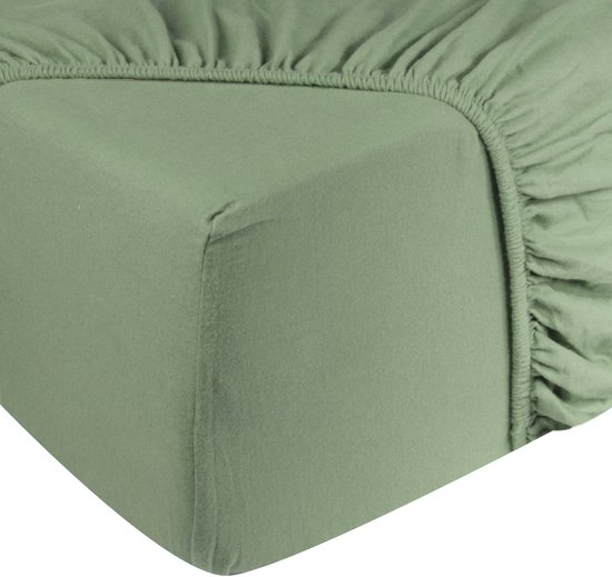 Drap-housse vert passé avec élastique intégral, gros plan du coin.