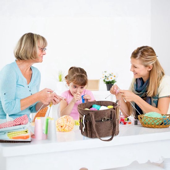 Drie vrouwen breien met een bruine corduroy breitas op tafel.