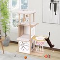 Kattenboom in woonkamer, met twee katten erop. Een kat springt naar de mand in basketbalstijl. Speelgoed en een plant staan op de vloer.