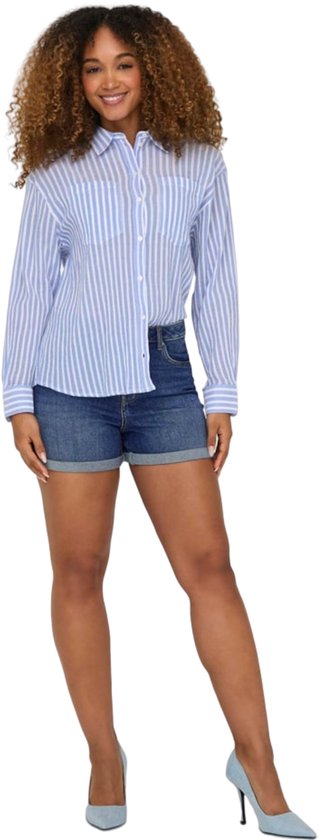 Model draagt een blauwgestreepte blouse en denim shorts met opgerolde zoom.