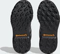 Zolen van zwarte wandelschoenen met oranje 'Continental' logo en grip-profiel.