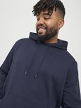 Close-up van een man met een brede glimlach in een donkerblauwe hoodie met trekkoordjes.