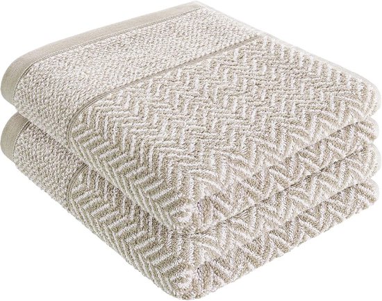 Deux serviettes sable avec motif chevrons empilées.