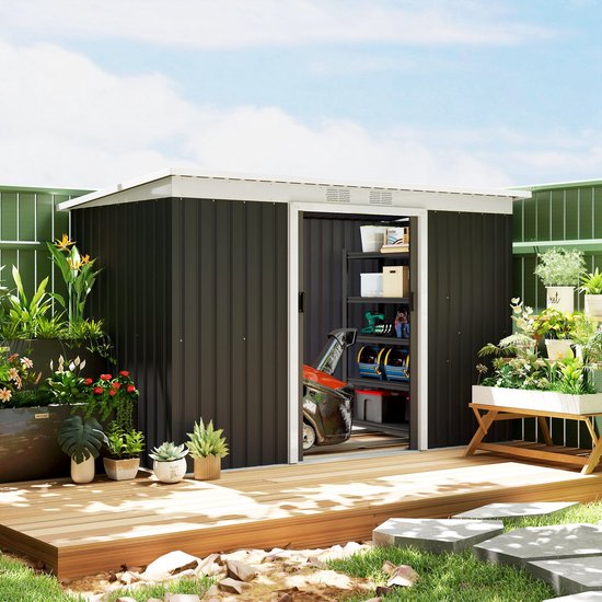 Donkergrijs metalen tuinhuis met open schuifdeuren, omringd door een tuin met planten.