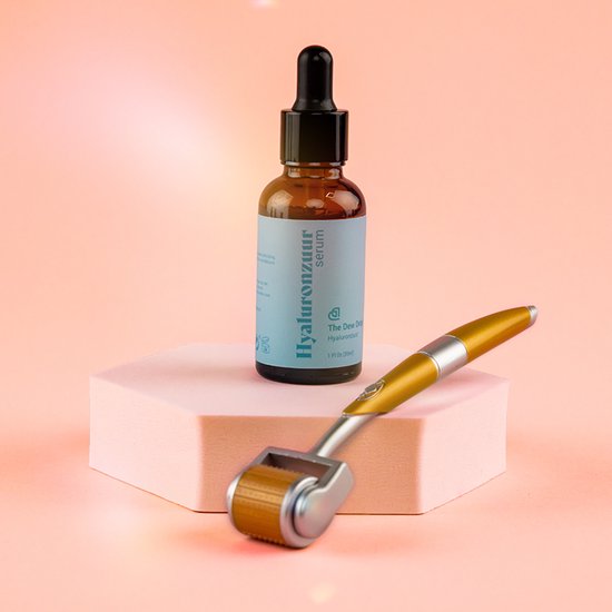 Glazen flesje Hyaluronzuur serum en een gouden dermaroller, op een roze zeshoekig plateau.