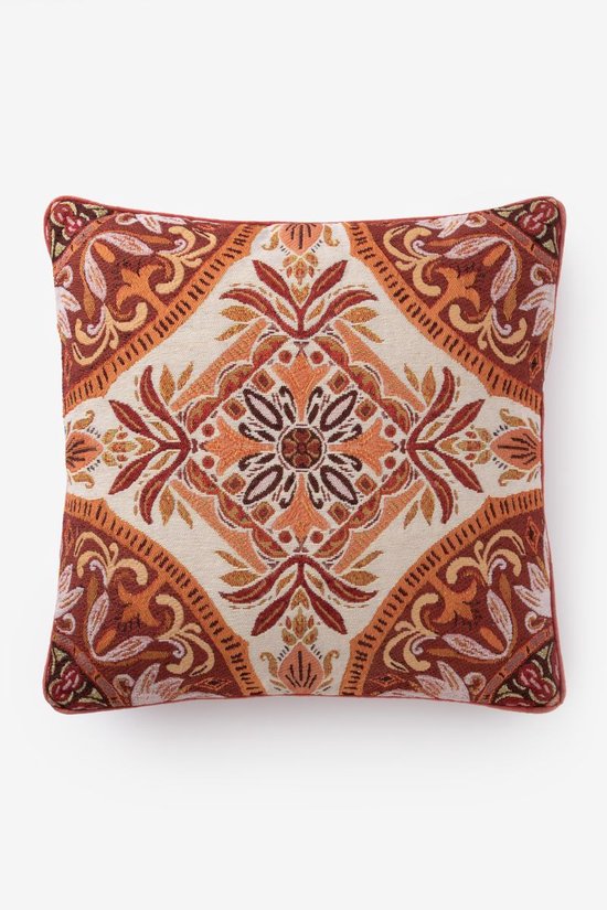 Coussin avec un motif mosaïque détaillé dans des tons de rouge, d'orange et de crème.