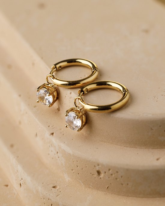 Gouden oorringen met hangende witte stenen, gezet met vier pootjes.