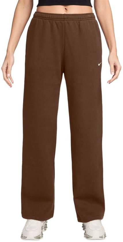 Een vrouw in een bruine Nike sportbroek met wijde pijpen en een klein Nike logo op de heup.