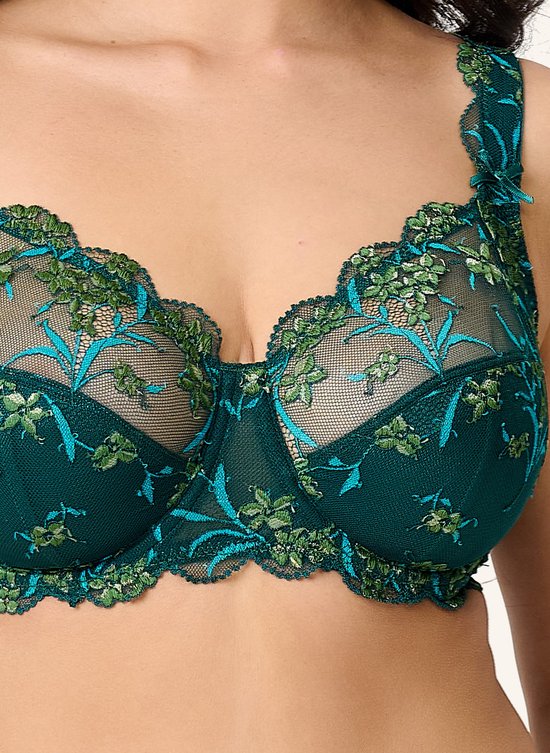 Close-up van de cups van een diepgroene kanten BH met bloemenborduurwerk in groen en turkoois.