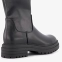 Close-up van de zwarte hiel en dikke profielzool van de laars.