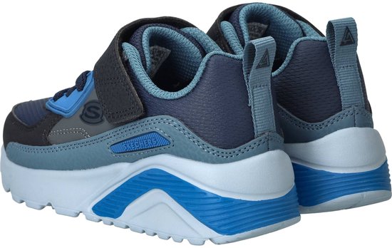 Achterkant van blauwe sneakers met grijze en donkergrijze details en klittenband.