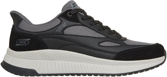 Zwarte sneaker met grijze mesh en suède accenten, witte zool met grijze details.