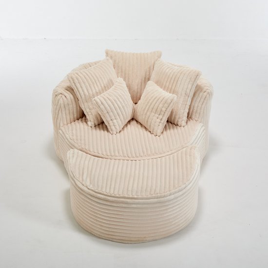 Beige fluwelen ronde loungestoel met voetenbank, met 5 kussens, in een studio.