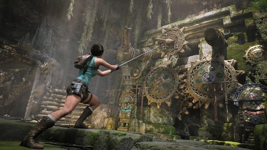 Lara Croft trekt aan een mechanisme met tandwielen in een oude, met mos begroeide stenen structuur.