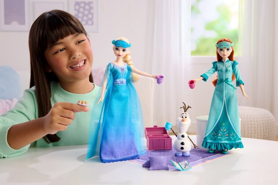 Een meisje speelt met Elsa en Anna poppen, Olaf en accessoires van de slaapfeestje set.