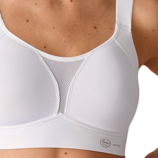 Close-up van een witte Anita Active sportbeha met ademend mesh-paneel tussen de cups en Anita Active-logo.
