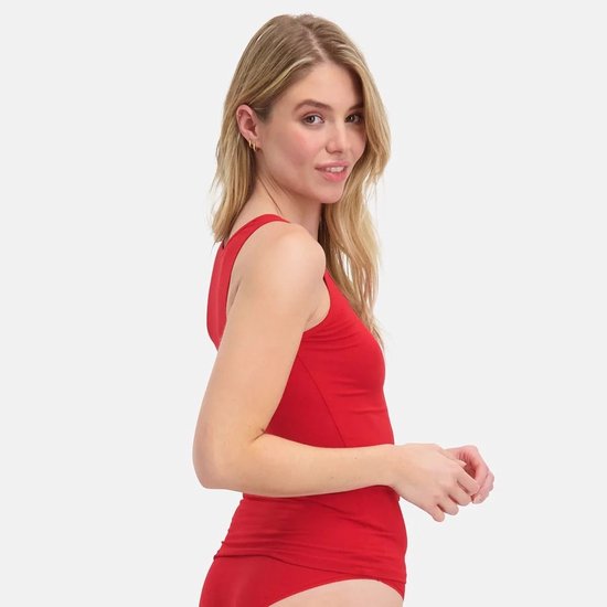 Zijaanzicht van een model in een felrode mouwloze top van zachte stof.