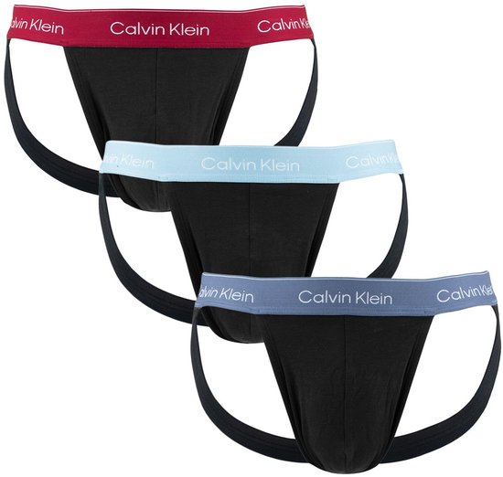 Drie zwarte Calvin Klein jockstraps met gekleurde logo-banden: rood, lichtblauw en grijs.