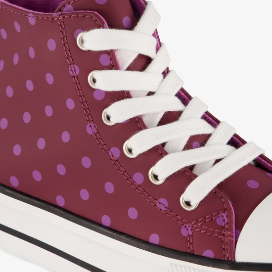 Detail van bordeauxrode hoge sneaker met roze polkadots en witte veters.