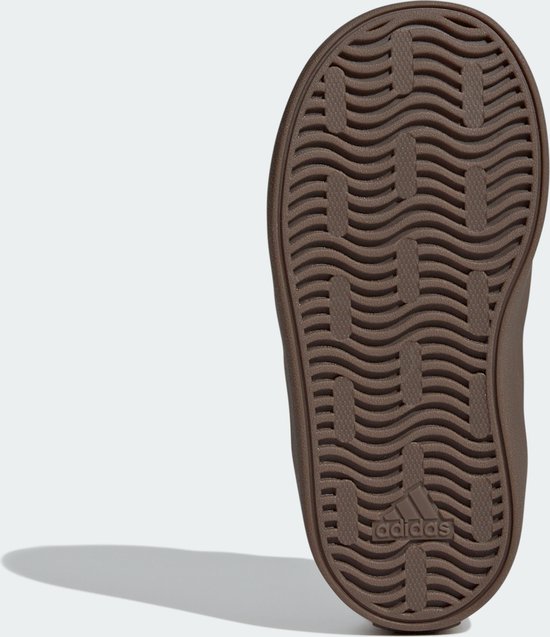 Onderkant van een bruine Adidas sneaker met golvend profiel.