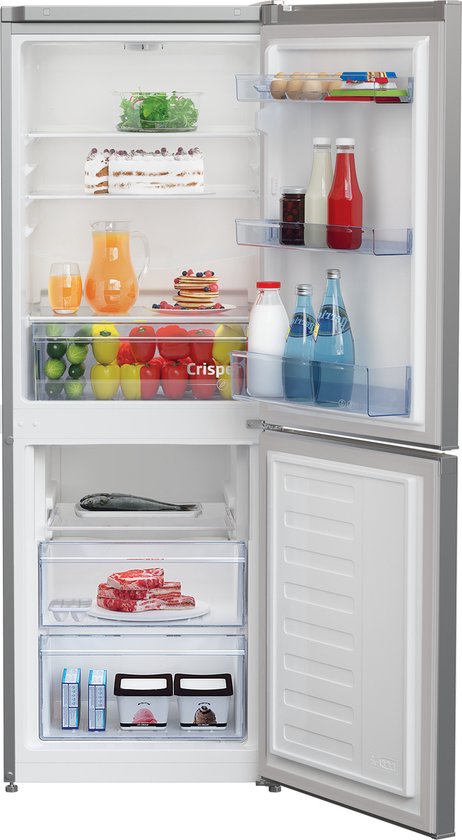 Beko koel-vriescombinatie open, met in de koelruimte een taart, sinaasappelsap, pannenkoeken, groenten, fruit, vlees en flessen.