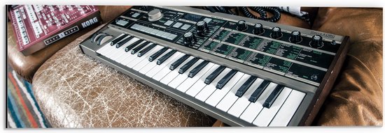 Dibond - Oud Keyboard op Bruine Leren Bank - 60x20 cm Foto op Aluminium (Wanddecoratie van metaal)