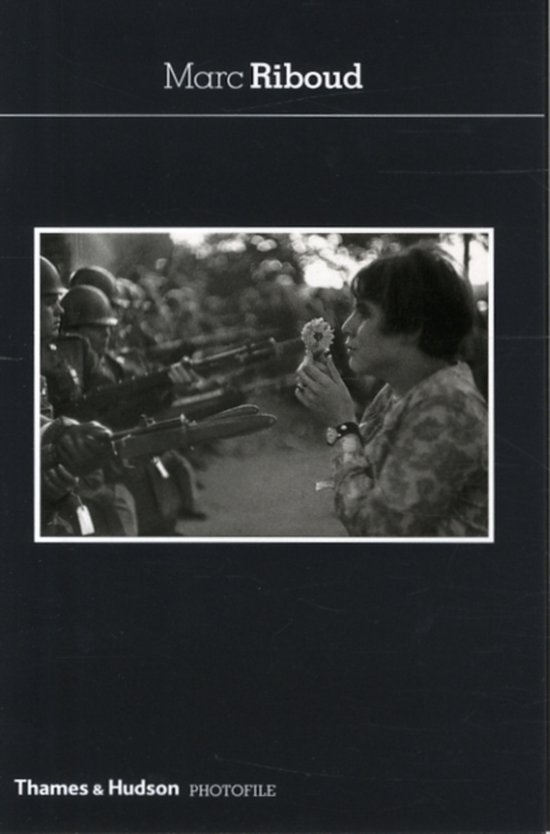 Een vrouw houdt een bloem vast voor een rij soldaten met geweren. Titel: Marc Riboud.