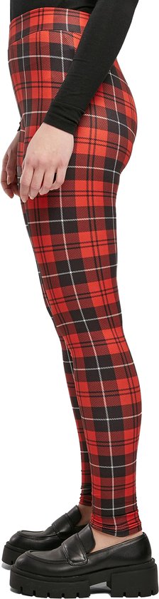 Zijprofiel van de benen van een vrouw in rode, zwart geruite legging.