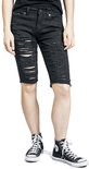 Zijzicht van een vrouw in zwarte, opengescheurde bermudashorts met rafelige zoom.