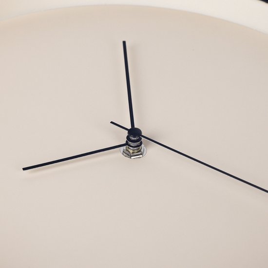 Gros plan d'une horloge ronde beige avec des aiguilles noires.
