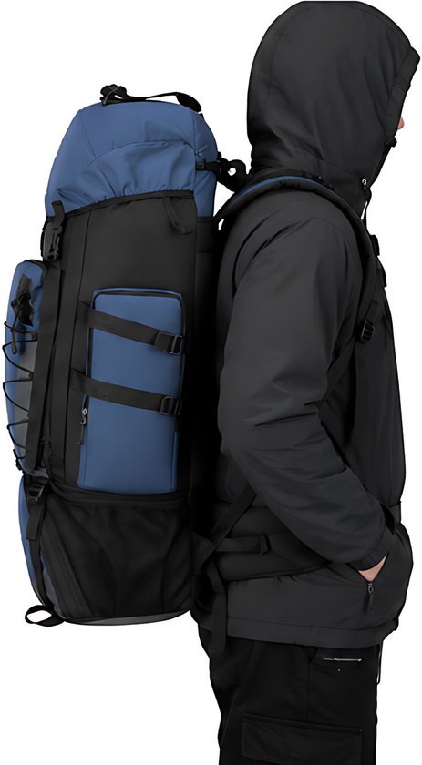 Zijaanzicht van een blauwe en zwarte 90L trekkingrugzak gedragen door een persoon.